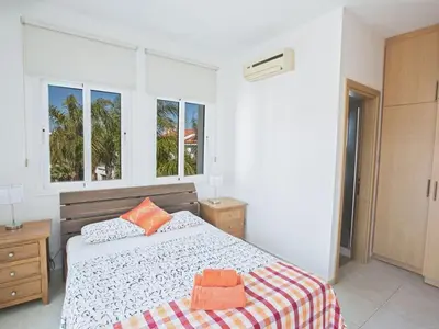 a white bedroom with a bed and two windows at Villa Mesogi, Modern 3Bdr Protaras Villa, Close To Fig Tree Bay Beach in Protaras