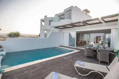 a villa with a swimming pool and a patio at Villa Fig Tree Bay Seafront, Luxury 5Bdr Seafront Protaras in Protaras