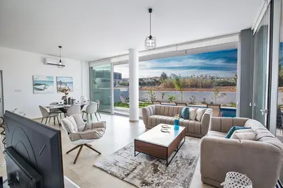 a living room with couches and a dining room at Villa Olive Thalassa, Brand New, Luxury 3Bdr Protaras Villa With Private Pool in Protaras