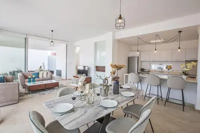 a dining room and living room with a table and chairs at Villa Olive Thalassa, Brand New, Luxury 3Bdr Protaras Villa With Private Pool in Protaras