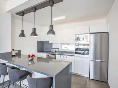 a kitchen with white cabinets and a large island with chairs at Villa Olive Platinum, New And Luxury 4Bdr Protaras Villa With Private Pool in Protaras
