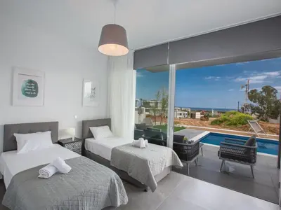 a bedroom with two beds and a view of a pool at Villa Olive Platinum, New And Luxury 4Bdr Protaras Villa With Private Pool in Protaras