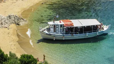 a boat on the water next to a beach at Villa Leoforos Dyo, Modern 3Bdr Protaras Villa With Pool, In The Centre in Protaras