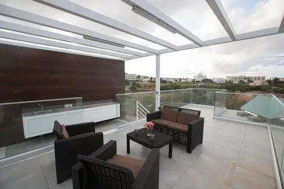 a balcony with chairs and tables and a large window at Villa Olive Gold, Luxury And Brand New 2Bdr Protaras Villa With Private Pool in Protaras