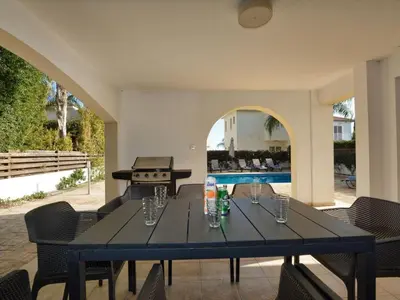a black table with chairs and a grill in a patio at Villa Protaras Paralia Spacious 4Bdr Central Protaras Villa in Protaras
