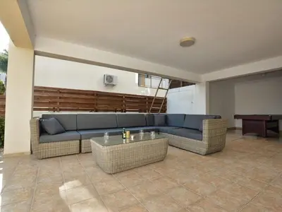 a living room with a blue couch and a table at Villa Protaras Paralia Spacious 4Bdr Central Protaras Villa in Protaras