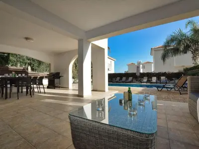 a patio with a glass table in a house at Villa Protaras Paralia Spacious 4Bdr Central Protaras Villa in Protaras