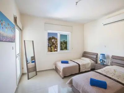 a bedroom with two beds and a mirror at Villa Mesogi Seafront, Stunning 4Bdr Fontline Protaras in Protaras