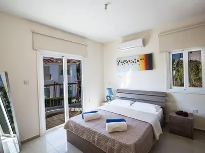 a bedroom with a bed with two towels on it at Villa Mesogi Seafront, Stunning 4Bdr Fontline Protaras in Protaras