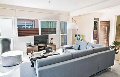 a living room with a couch and a tv at Villa Mesogi Seafront, Stunning 4Bdr Fontline Protaras in Protaras