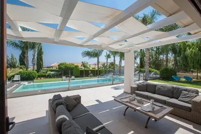 a patio with couches and a table and a pool at Villa Protaras Sunshine, Stylish 4Bdr Villa With Pool, Close To Fig Tree in Protaras