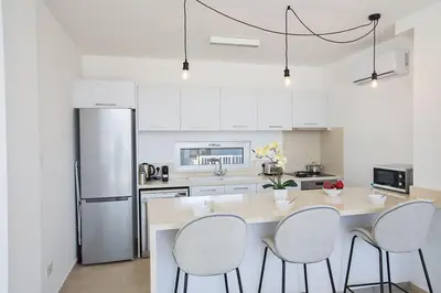 a kitchen with a table and chairs and a refrigerator at Villa Olive Chrysos, Brand New, Luxury 3 Bdr Protaras Villa, With Private Pool in Protaras