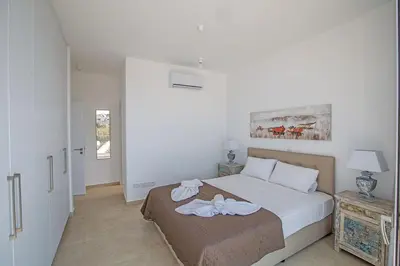 a bedroom with a bed with two towels on it at Villa Olive Chrysos, Brand New, Luxury 3 Bdr Protaras Villa, With Private Pool in Protaras