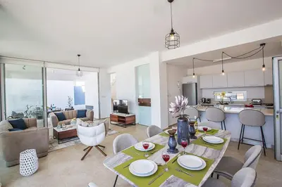 a kitchen and living room with a table and chairs at Villa Olive Chrysos, Brand New, Luxury 3 Bdr Protaras Villa, With Private Pool in Protaras