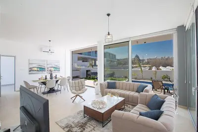 a living room with a couch and a tv at Villa Olive Chrysos, Brand New, Luxury 3 Bdr Protaras Villa, With Private Pool in Protaras
