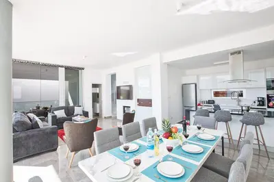 a living room with a table and chairs at Villa Olive Loux,Brand New, Exquisite 5Bdr Protaras Villa With Pool in Protaras