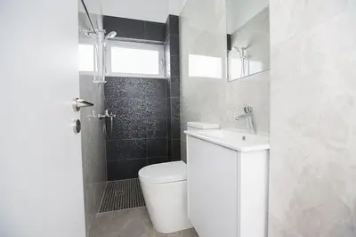 a white bathroom with a toilet and a sink at Villa Olive Loux,Brand New, Exquisite 5Bdr Protaras Villa With Pool in Protaras