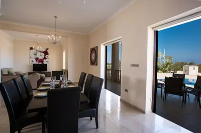 a dining room and living room with a table and chairs at Villa Protaras Deluxe, Fabulous And Luxurious 7Bdr Villa, Close To Fig Tree in Protaras