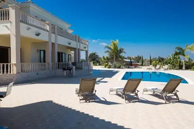 a group of chairs sitting next to a swimming pool at Villa Protaras Deluxe, Fabulous And Luxurious 7Bdr Villa, Close To Fig Tree in Protaras