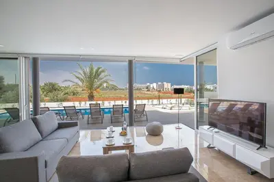 a living room with a couch and a television at Villa Manta Platina - Brand New Luxury 3 Bedroom Protaras Villa in Protaras