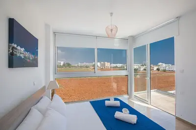 a living room with a couch and a large window at Villa Manta Platina - Brand New Luxury 3 Bedroom Protaras Villa in Protaras