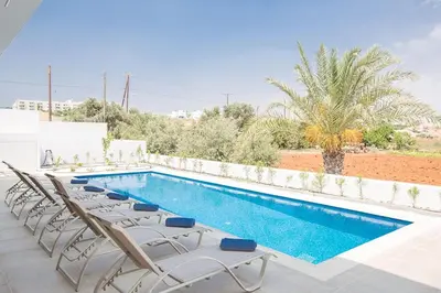 a swimming pool with chaise lounge chairs and a pool at Villa Manta Platina - Brand New Luxury 3 Bedroom Protaras Villa in Protaras