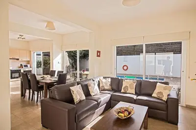 a living room with a couch and a table at Villa Dafnis Sunshine - Modern 3 Bedroom Central Protaras Villa With Pool in Protaras