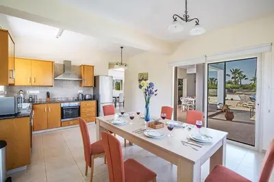 a kitchen and dining room with a table and chairs at Villa Akefalo - Beautiful 3 Bedroom Protaras Villa With Private Pool in Protaras