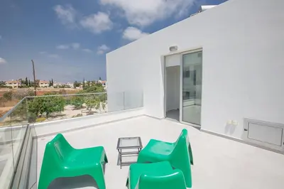 a room with two green chairs on a balcony at Villa Ochosto Helios - Beautiful 5 Bedroom Protaras Villa - Walking Distance in Protaras
