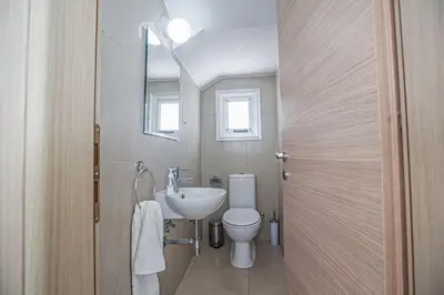 a bathroom with a sink and a toilet and a mirror at Villa Adaman - Stunning 3 Bedroom Seafront Villa With Pool - Close To The Beach in Ayia Napa