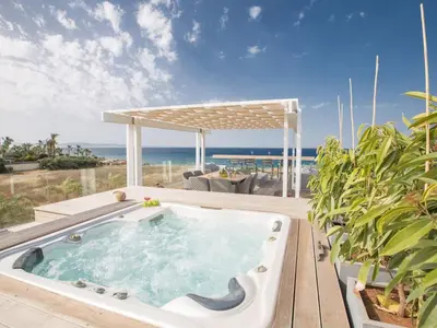 a hot tub on a deck with the ocean in the background at Villa Papadopo - Luxury 3 Bedroom Villa With Private Pool, Hot Tub And Sea Views in Paralimni