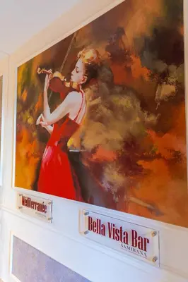 a painting of a woman in a red dress playing a violin at Leonardo Boutique Hotel Larnaca in Larnaka