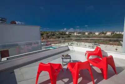two red chairs and a table on a balcony at Villa Ochosto Chrysos - Stunning 5 Bedroom Protaras Villa - Close To Fig Tree in Protaras