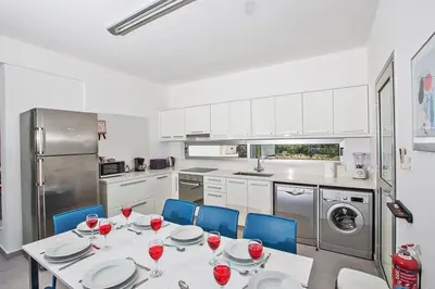 a kitchen with a table with wine glasses on it at Villa Ochosto Chrysos - Stunning 5 Bedroom Protaras Villa - Close To Fig Tree in Protaras
