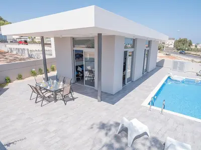a patio with a table and a swimming pool at Villa Protaras Miramar, Luxury And New 5Bdr Protaras Villa With Pool in Protaras