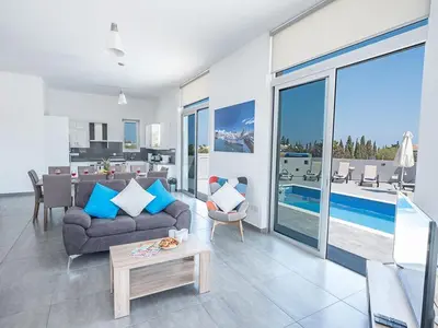 a living room with a couch and a table at Villa Protaras Miramar, Luxury And New 5Bdr Protaras Villa With Pool in Protaras