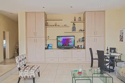 a living room with a television and a table at Pallini Court in Protaras