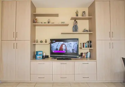 a living room with a tv sitting on a cabinet at Pallini Court in Protaras