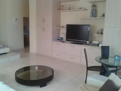 a living room with a tv and a table at Pallini Court in Protaras