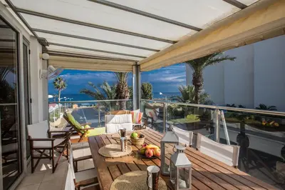 a patio with a table and chairs on a balcony at Pallini Court in Protaras