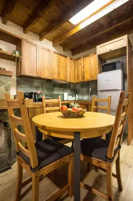 a kitchen with a wooden table with a bowl of fruit on it at Cozy mountain apartment in Platres in Platres