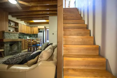 a staircase in a living room with a leather couch at Cozy mountain apartment in Platres in Platres