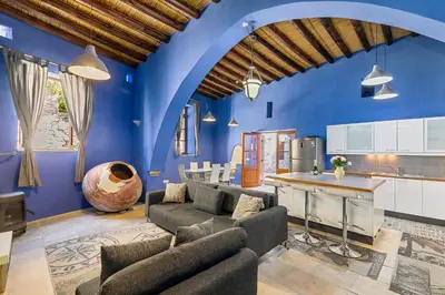 a blue living room with a couch and a kitchen at Blue Oak House in Kato Drys