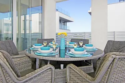 a table with plates and glasses on a patio at Villa Nova in Protaras