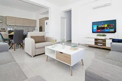 a living room with a couch and a table with a tv at Villa Nova in Protaras