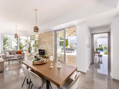 a dining room and living room with a table and chairs at Milos lifestyle villas H27 in Protaras
