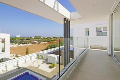 an open balcony with a view of a building at Villa Medusa in Protaras