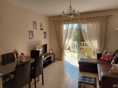a living room with a table and a dining room at Nissi Golden Sands Family Apartment in Ayia Napa