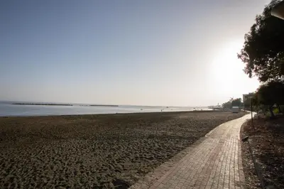 a brick path on a beach next to the water at Mayra Seafront Luxury Apartment (BREAKBOOKING-CY) in Limassol