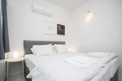 a white bed with white sheets and pillows at Mayra Seafront Luxury Apartment (BREAKBOOKING-CY) in Limassol